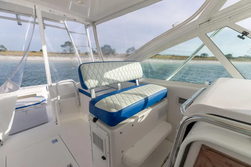 Miss Big Gun Yacht Photos Pics Interior of 2000 Cabo 35 Express boat with blue and white seating, ocean view.