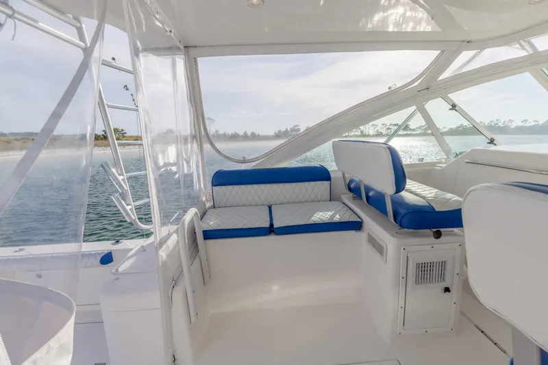Miss Big Gun Yacht Photos Pics Interior of 2000 Cabo 35 Express boat with blue and white seating, overlooking water.