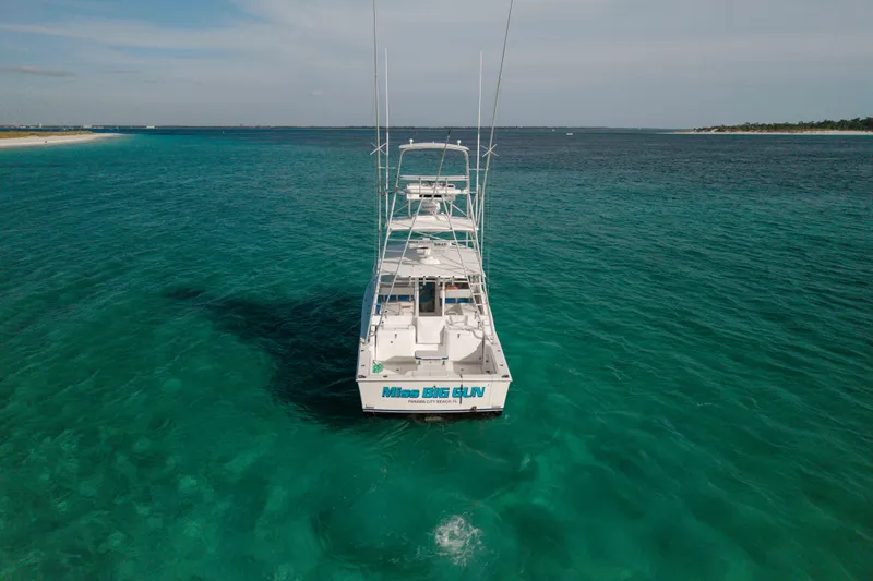Miss Big Gun Yacht Photos Pics 2000 Cabo 35 Express boat on clear turquoise water, viewed from the rear.