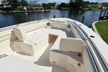  Yacht Photos Pics 2022 Grady-White Canyon 336 boat interior with seating, docked by a scenic waterfront.