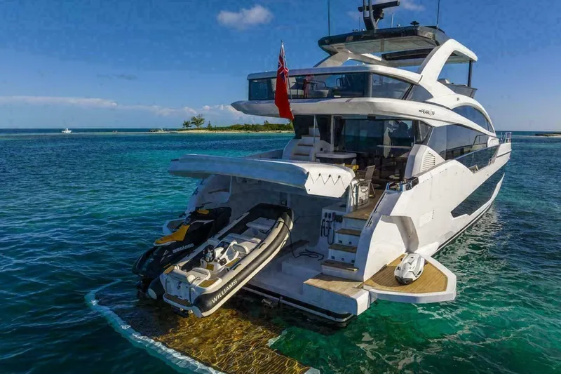 Pearl 72 Indulgence Yacht Photos Pics Luxurious 2025 Pearl 72 yacht with jet skis, cruising in clear blue waters.