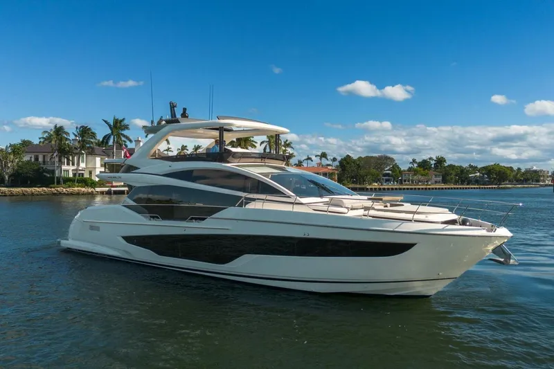 Pearl 72 Indulgence Yacht Photos Pics Luxurious 2025 Pearl 72 yacht cruising on a sunny day near waterfront homes.