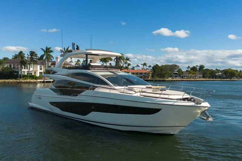 Pearl 72 Indulgence Yacht Photos Pics Luxurious 2025 Pearl 72 yacht cruising on a sunny day near waterfront homes.