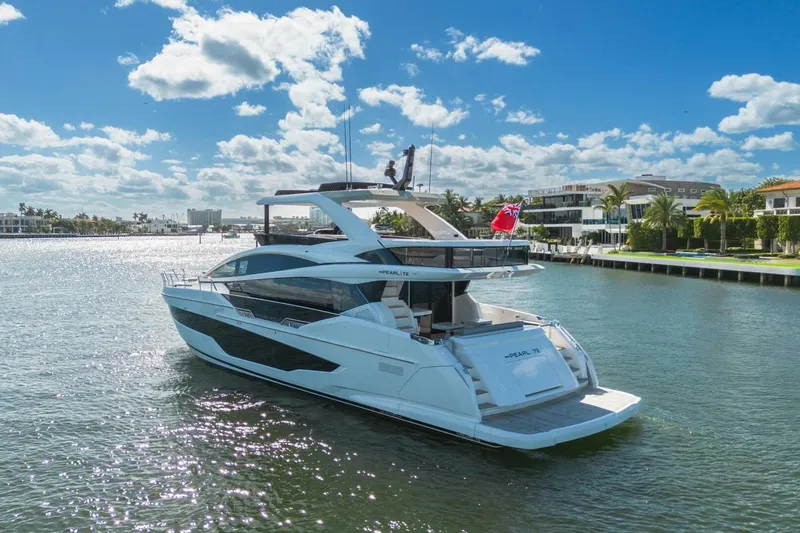 Pearl 72 Indulgence Yacht Photos Pics Luxurious 2025 Pearl 72 yacht cruising on a sunny day, surrounded by waterfront homes.