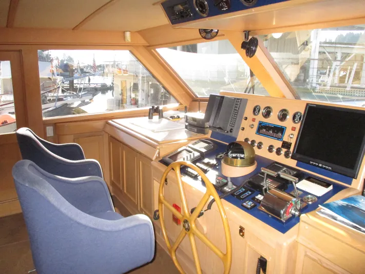 Accord Yacht Photos Pics 1984 McQueen Flush Deck Motoryacht helm with navigation instruments and blue captain chairs.