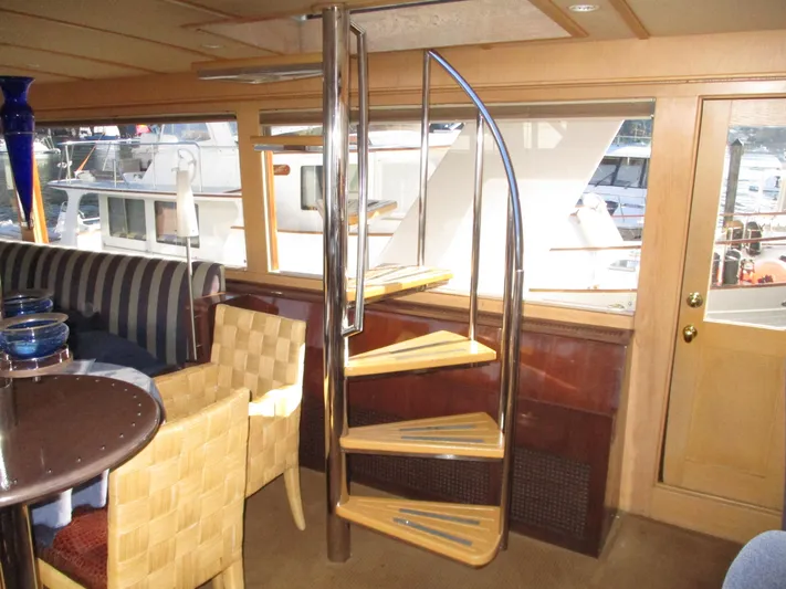 Accord Yacht Photos Pics Interior of 1984 McQueen Flush Deck Motoryacht with spiral staircase and elegant seating area.