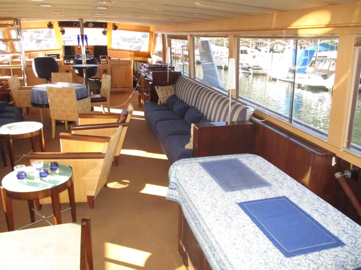 Accord Yacht Photos Pics Luxurious interior of a 1984 McQueen Flush Deck Motoryacht with elegant seating and large windows.