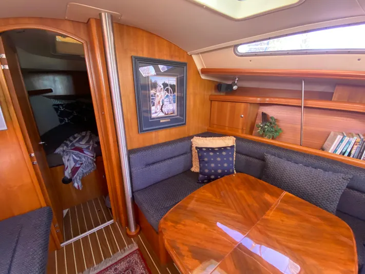 First Admiral Yacht Photos Pics Interior of a 2006 Hunter 38 yacht with wooden table and seating area.