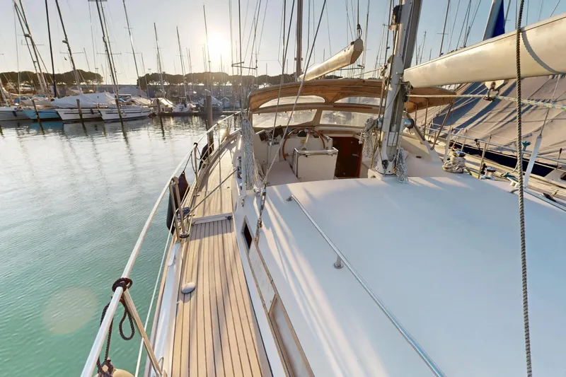  Yacht Photos Pics Amel Super Maramu 2000 sailboat, 2002 model, docked in a serene marina at sunset.