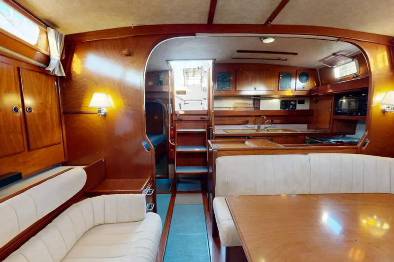  Yacht Photos Pics Luxurious interior of 2002 Amel Super Maramu 2000 yacht with wood finish and cozy seating.