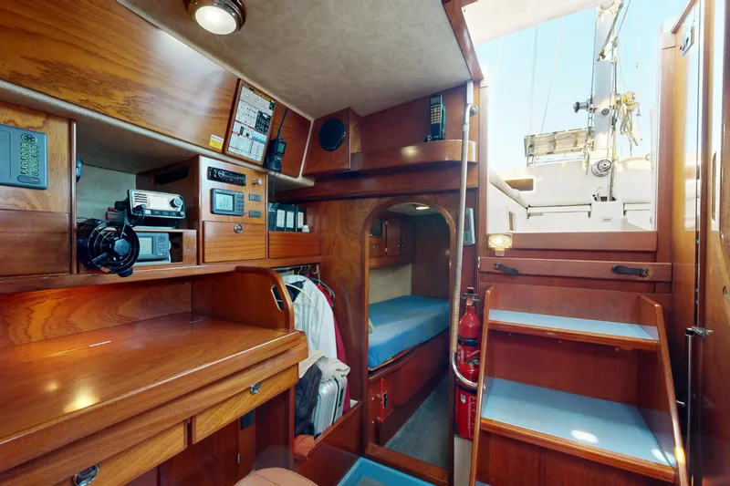  Yacht Photos Pics Interior of 2002 Amel Super Maramu 2000 sailboat with wooden cabinetry and navigation equipment.