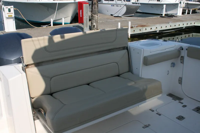  Yacht Photos Pics 2018 Pursuit S 328 Sport boat with beige seating at a marina.