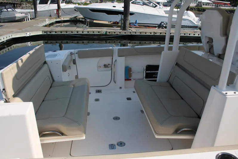  Yacht Photos Pics 2018 Pursuit S 328 Sport boat interior with beige seating at a marina.