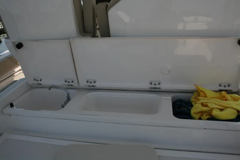  Yacht Photos Pics 2018 Pursuit S 328 Sport boat storage compartments with sink and cleaning supplies.