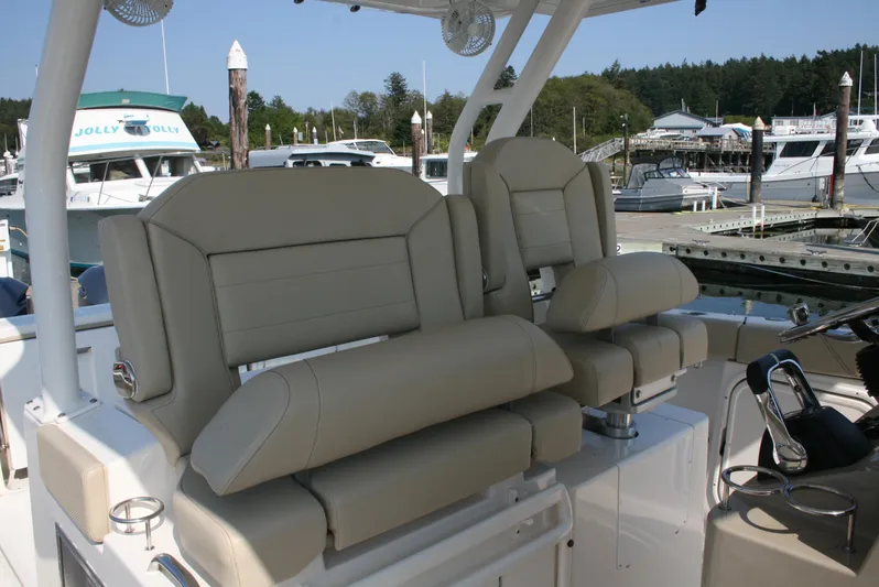  Yacht Photos Pics 2018 Pursuit S 328 Sport boat seats at marina, featuring beige upholstery and modern design.
