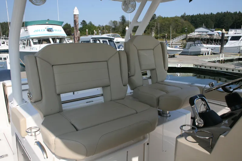  Yacht Photos Pics 2018 Pursuit S 328 Sport boat seats at marina, featuring beige upholstery and modern design.