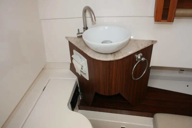  Yacht Photos Pics 2018 Pursuit S 328 Sport boat bathroom with modern sink and wooden cabinetry.