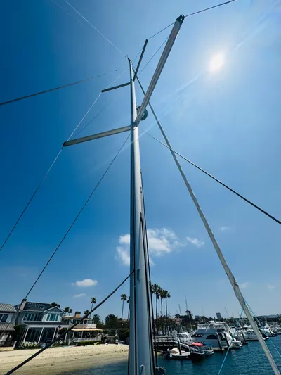 Happy Hour Yacht Photos Pics Sailboat mast of 2020 Beneteau Oceanis 41.1 under clear blue sky at marina.
