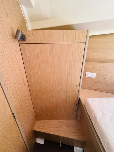 Happy Hour Yacht Photos Pics Interior cabin of 2020 Beneteau Oceanis 41.1 yacht, featuring wooden paneling and a cozy bed.