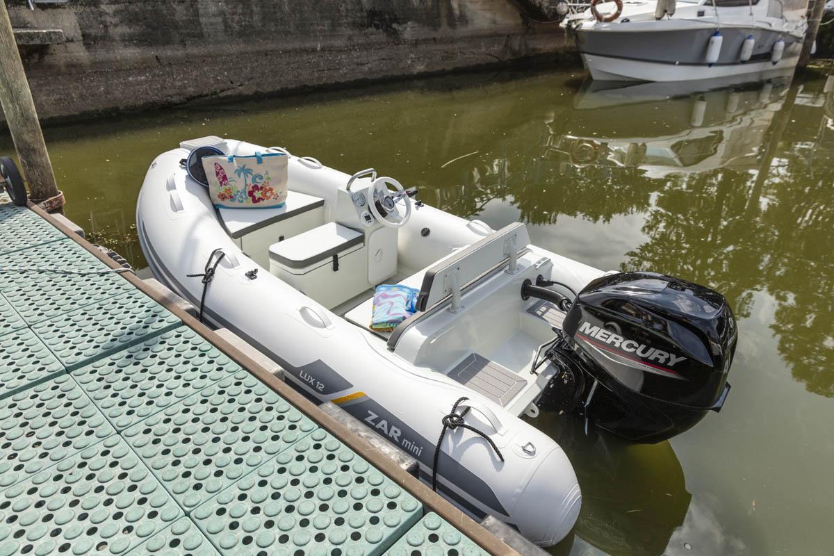2023 ZAR Mini LUX 12 inflatable boat docked with Mercury outboard motor.