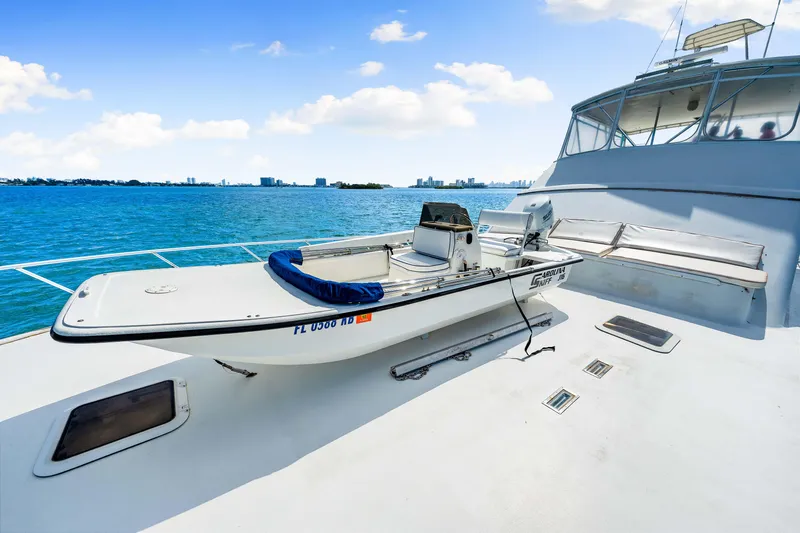 Bahama Belle Yacht Photos Pics Small boat on deck of Blackwell 72 yacht, 1996 model, with ocean and city skyline in background.