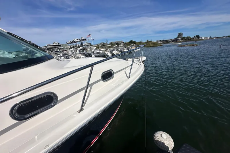  Yacht Photos Pics 2010 Pursuit OS 315 Offshore boat docked on calm water under blue sky.