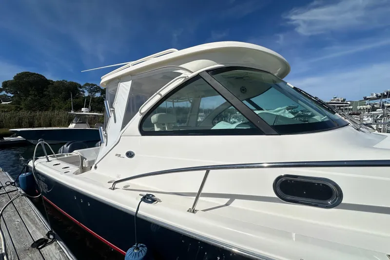  Yacht Photos Pics 2010 Pursuit OS 315 Offshore boat docked under clear blue sky.
