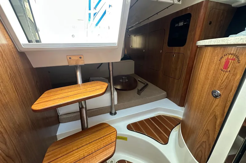  Yacht Photos Pics 2010 Pursuit OS 315 Offshore cabin interior with wooden steps and seating area.