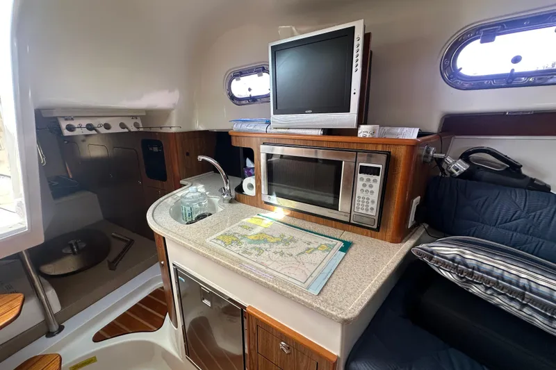  Yacht Photos Pics 2010 Pursuit OS 315 Offshore cabin with kitchenette, microwave, and TV.