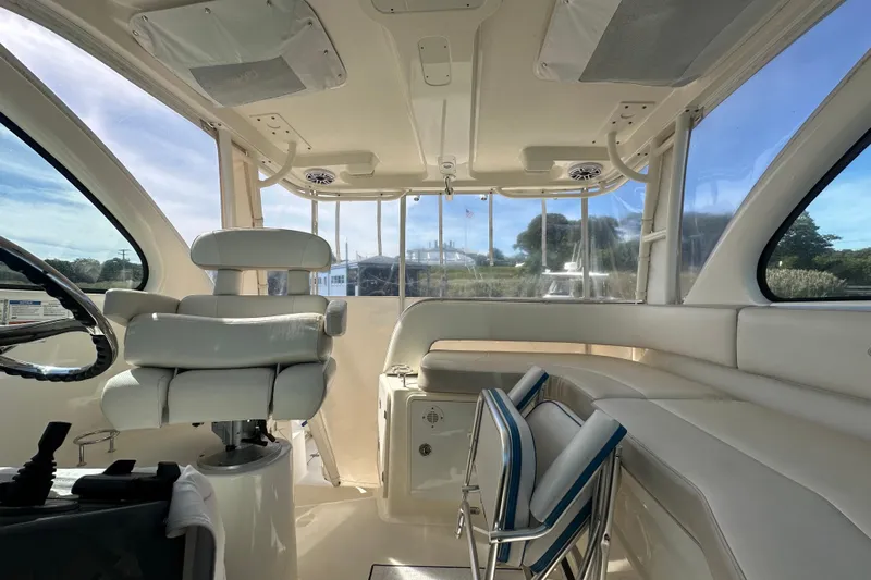  Yacht Photos Pics Interior of 2010 Pursuit OS 315 Offshore boat with white seating and steering wheel.