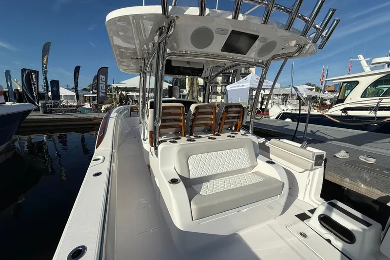  Yacht Photos Pics 2026 Mag Bay 38 CC boat interior at a marina, showcasing seating and helm station.