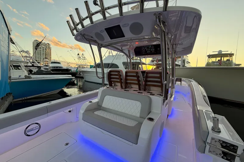  Yacht Photos Pics 2026 Mag Bay 38 CC boat interior with seating, illuminated deck, and marina backdrop at sunset.