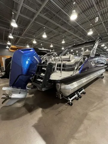2025 Barletta Boats R23UCA pontoon with blue motor in showroom.