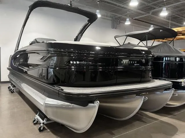 2025 Barletta Boats R23UCA pontoon in showroom, sleek black design, modern features.