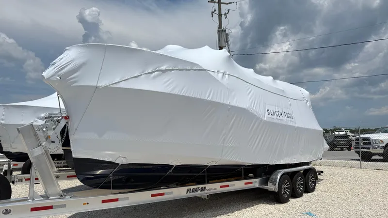  Yacht Photos Pics 2026 Ranger Tugs R-27 boat covered on trailer under cloudy sky.
