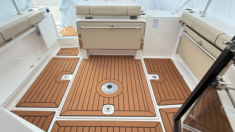  Yacht Photos Pics 2026 Ranger Tugs R-27 boat interior with teak-style flooring and beige seating.