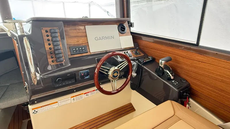  Yacht Photos Pics 2026 Ranger Tugs R-27 helm with Garmin navigation, wood accents, and leather seating.