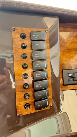  Yacht Photos Pics Control panel of 2026 Ranger Tugs R-27 boat with labeled switches on wood finish.