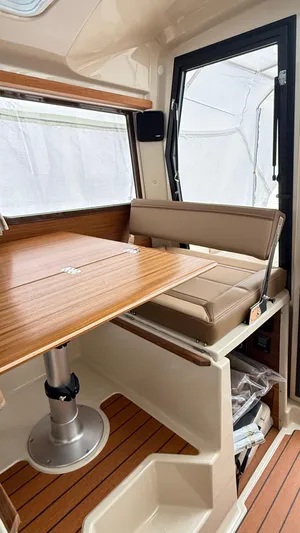  Yacht Photos Pics 2026 Ranger Tugs R-27 interior with wooden table and cushioned seating.