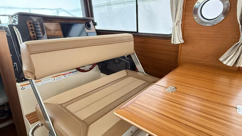  Yacht Photos Pics Interior of 2026 Ranger Tugs R-27, featuring wood accents and beige seating.