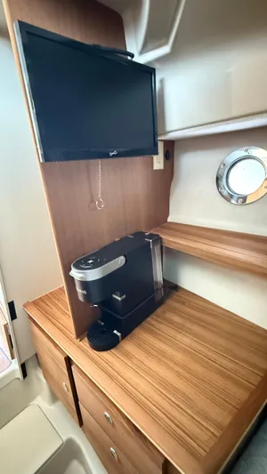  Yacht Photos Pics 2026 Ranger Tugs R-27 interior with TV and coffee maker on wooden counter.