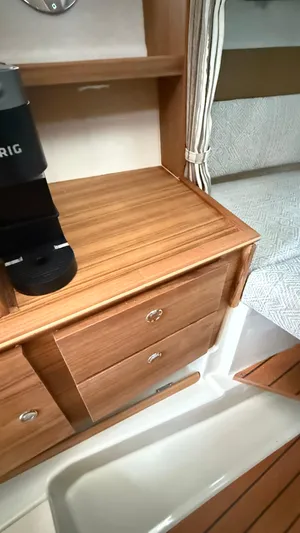  Yacht Photos Pics Interior of 2026 Ranger Tugs R-27, featuring wooden cabinetry and a cozy sleeping area.