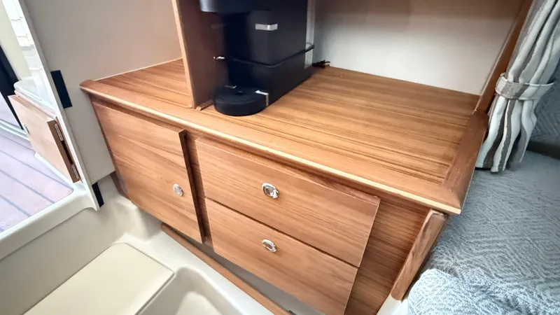  Yacht Photos Pics Interior of 2026 Ranger Tugs R-27 with wooden cabinetry and coffee maker.