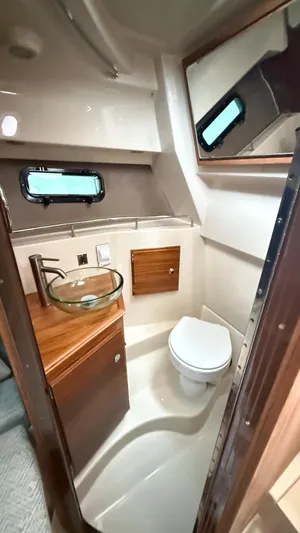  Yacht Photos Pics 2026 Ranger Tugs R-27 boat bathroom with modern fixtures and wooden cabinetry.
