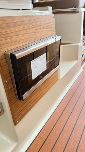  Yacht Photos Pics 2026 Ranger Tugs R-27 interior with wood paneling and built-in appliance.