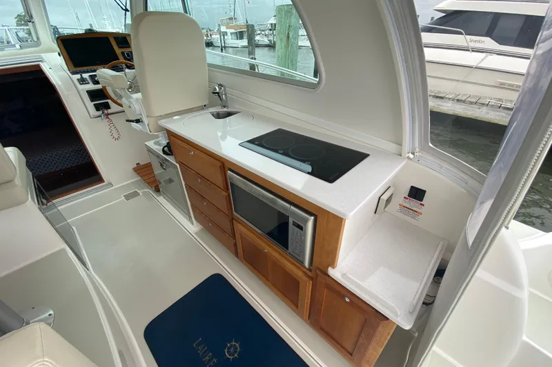 Laure Marie Yacht Photos Pics 2020 Back Cove 34O yacht interior with kitchenette, featuring stove, sink, and microwave.