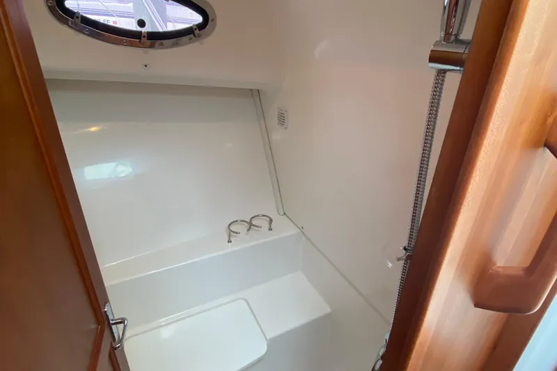 Laure Marie Yacht Photos Pics 2020 Back Cove 34O boat interior shower with porthole and wooden door.