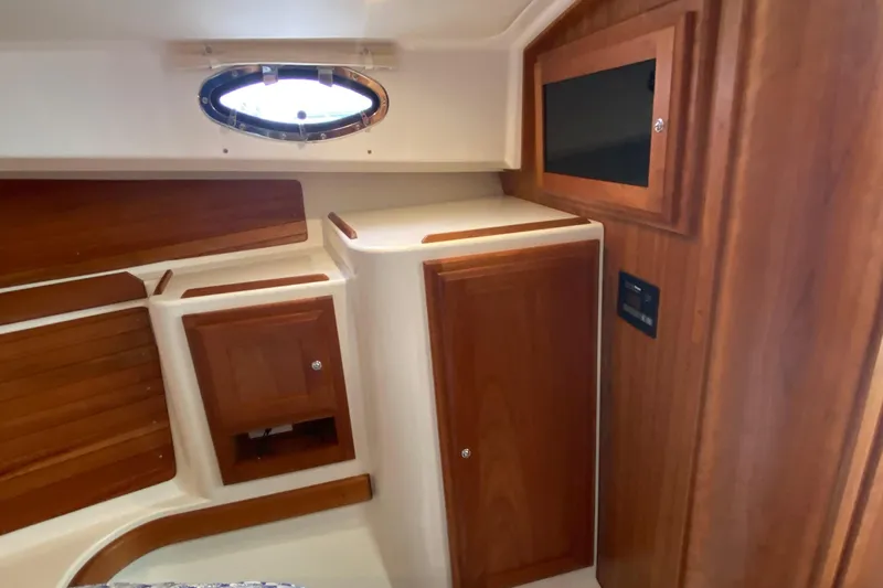 Laure Marie Yacht Photos Pics Interior of 2020 Back Cove 34O yacht with wooden cabinetry and porthole window.