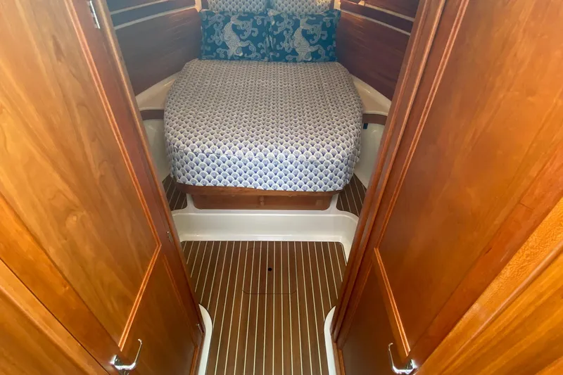 Laure Marie Yacht Photos Pics 2020 Back Cove 34O cabin interior with wooden finish and patterned bedding.