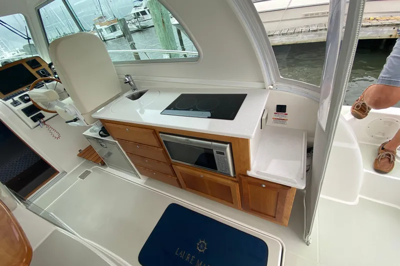 Laure Marie Yacht Photos Pics 2020 Back Cove 34O yacht interior with kitchenette, featuring stove, sink, and microwave.